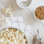 En skål med popcorn og salt og upoppa popcorn, for å illustrere volumspising og volummat.